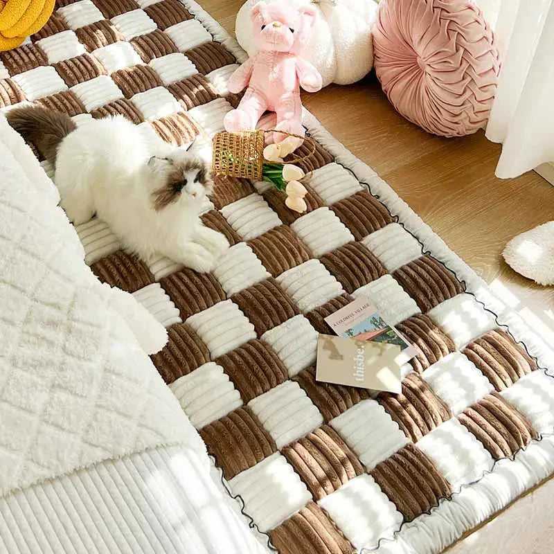 Un chat couché sur une couverture à côté d’un animal en peluche sur une housse de canapé à carreaux crème (Cream Check Sofa Cover)