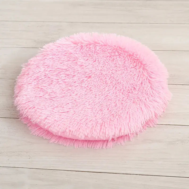 Lit rond pour petits animaux : balle rose moelleuse sur sol en bois
