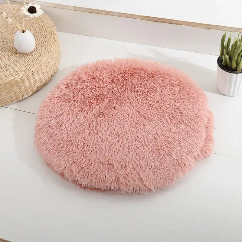 Lit rond rose pour petits chats et chiens sur table blanche